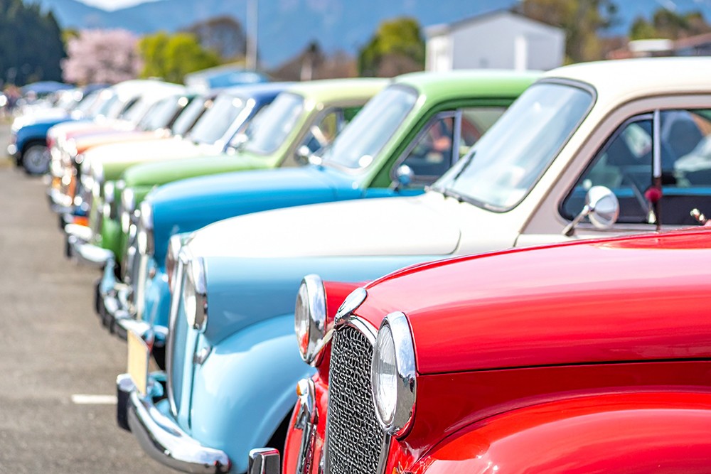 駐車場に並ぶカラフルなクラシックカーの展示