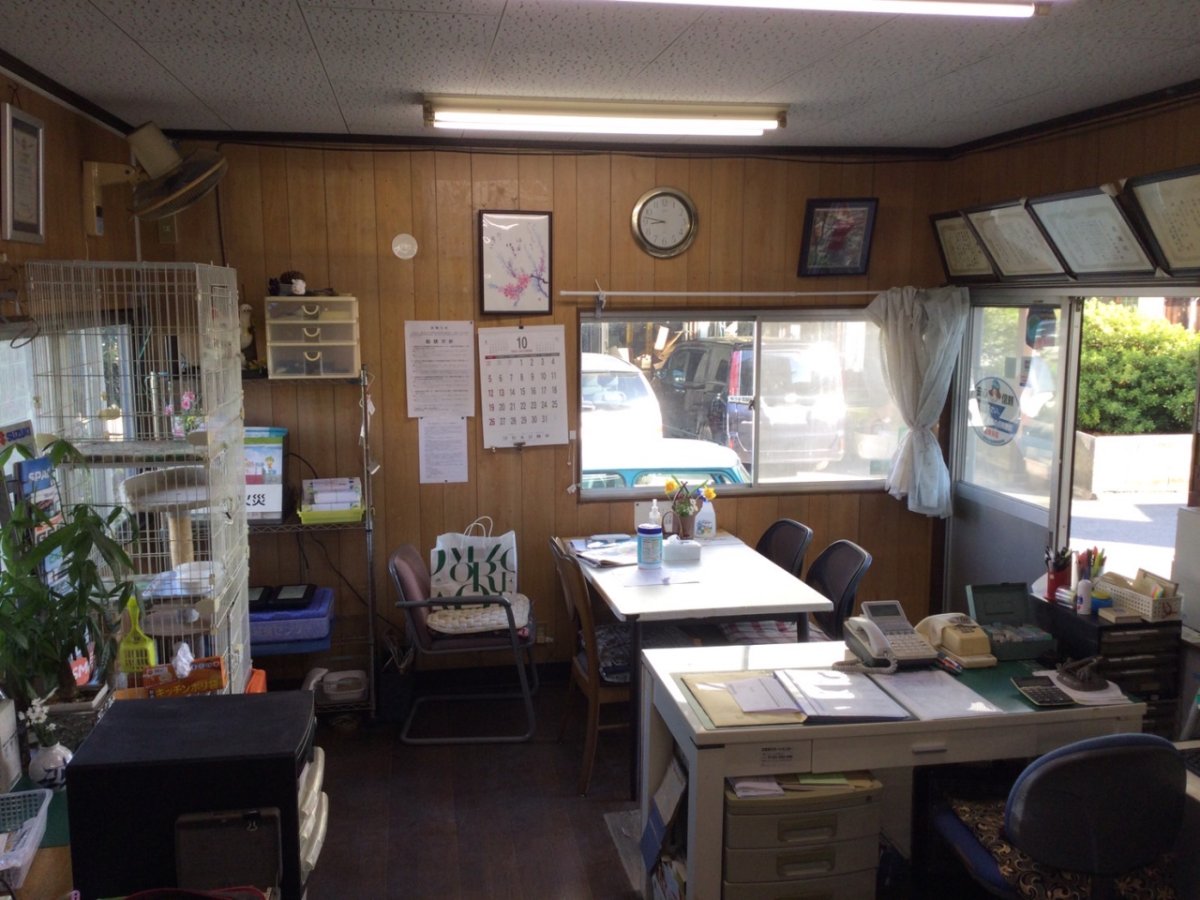 木目調の壁に囲まれたオフィス内での事務作業スペース