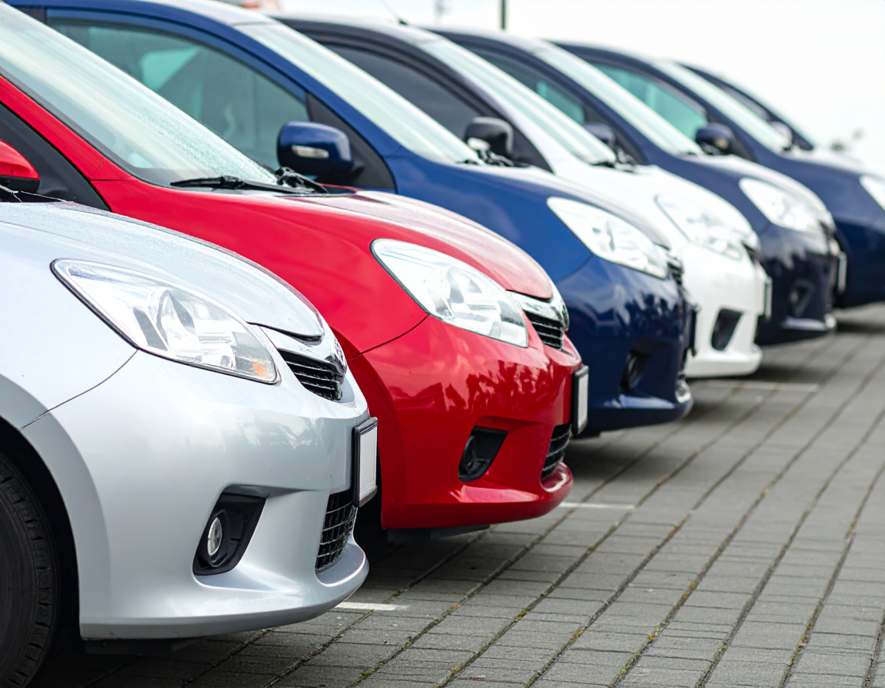 販売店の駐車場に並んだ新車の列