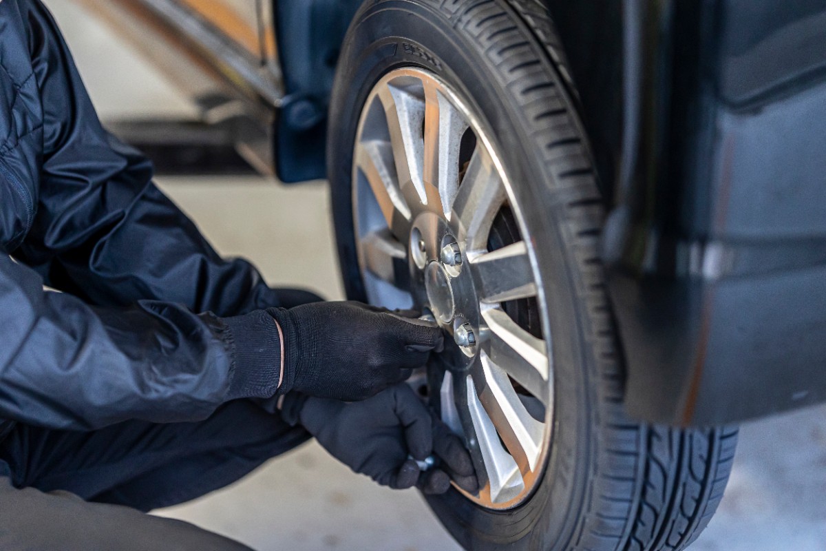 作業服を着た整備士がタイヤのホイールボルトを調整している様子